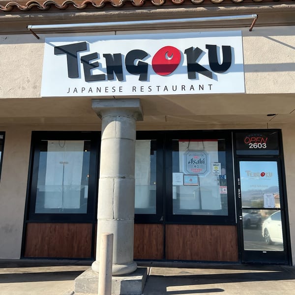 The exterior of Tengoku Japanese Restaurant, featuring its sign, entrance, and a decorative column.